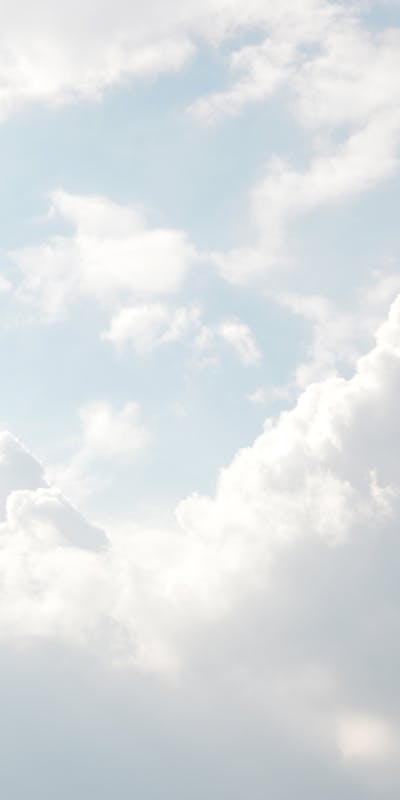 About Mindmotion A serene view of thick, fluffy clouds set against a bright blue sky, perfect for backgrounds.