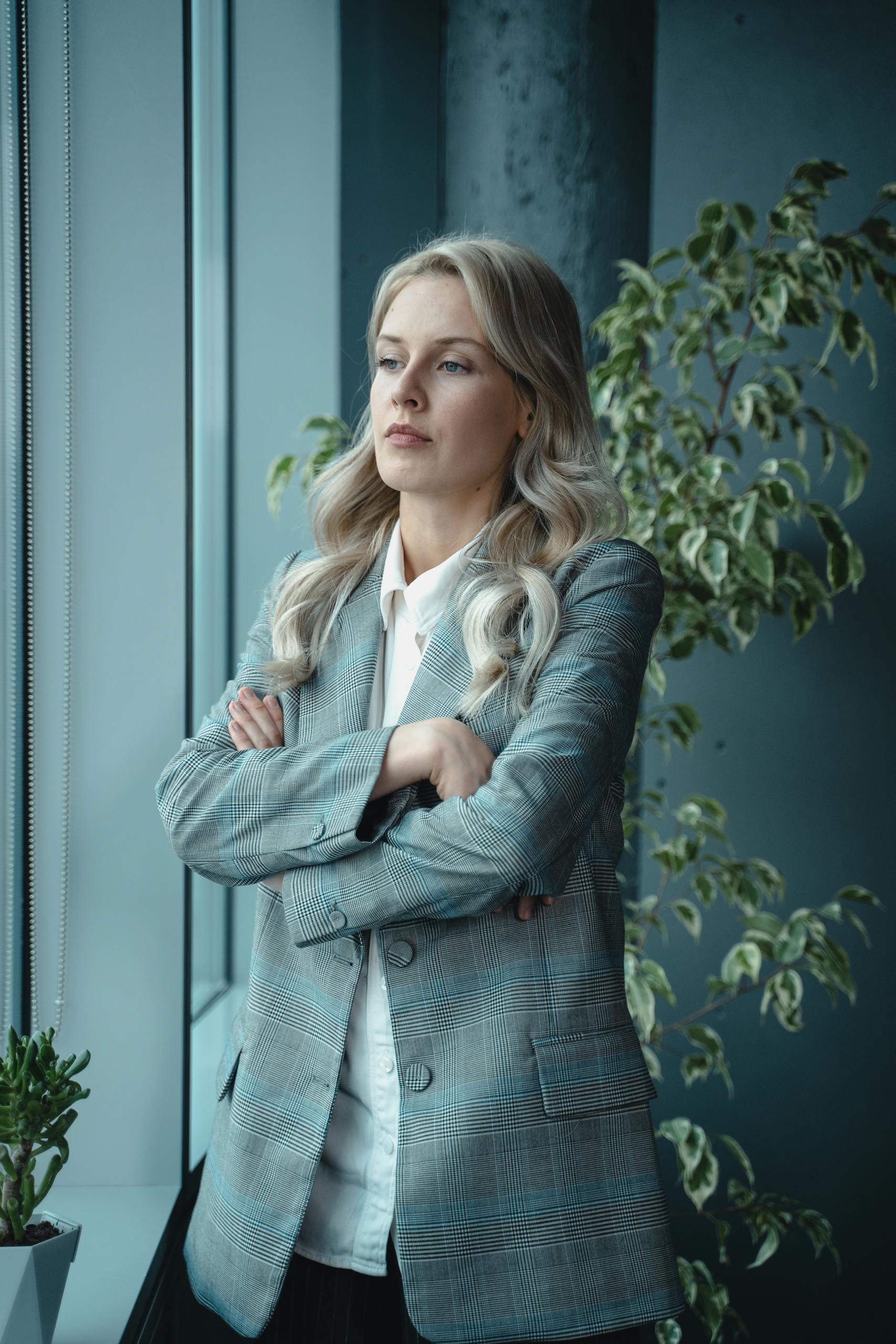How to deal with anger A poised female executive standing by a window, embodying leadership and professionalism.
